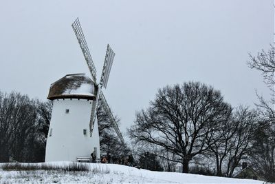 Traditional windmill against sky during winter