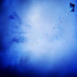 Low angle view of airplane flying against blue sky