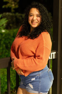 Portrait of smiling young woman by railing