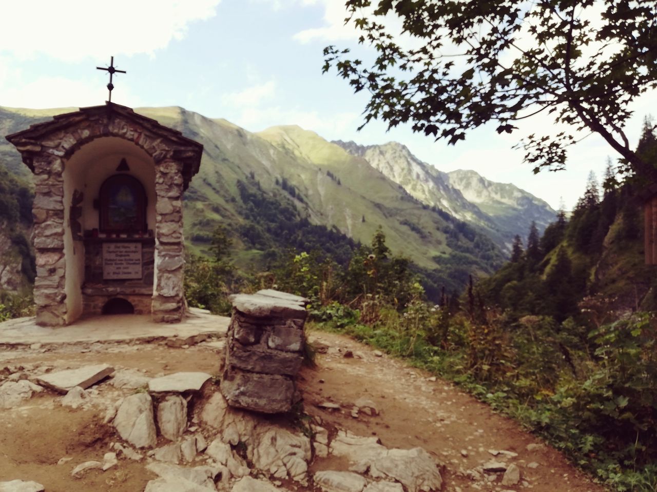 STONE WALL BY BUILDING AGAINST MOUNTAINS