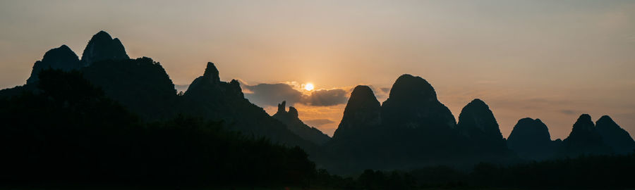Panoramic view of silhouette mountains against sky during sunset
