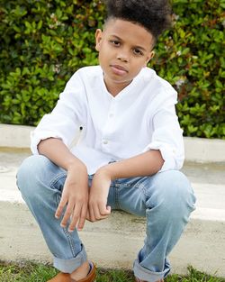 Portrait of young man sitting on field