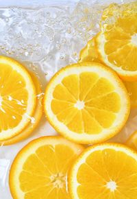 Close-up fresh slices of juicy orange on white background. slices of orange in sparkling water.