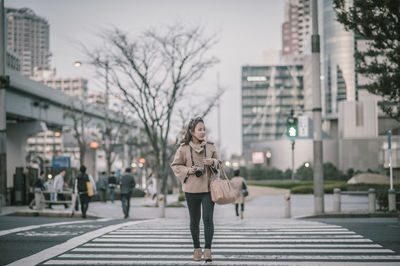 Full length of woman walking on street in city