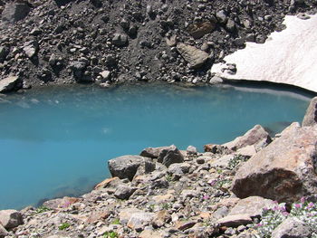 Rock formations by lake against sky