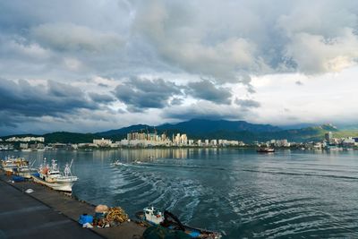 View of marina in city against cloudy sky