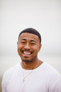 Mixed race man smiling at beach