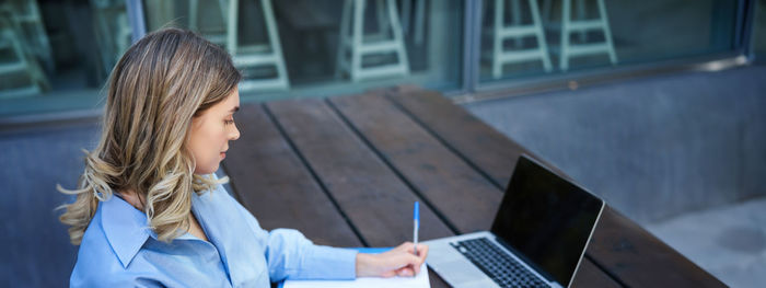 Young woman using laptop at table