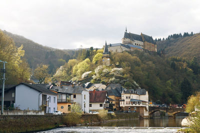 Houses in town by mountains against sky