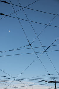 Low angle view of power lines against clear blue sky