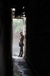 Side view of man leaning on wall