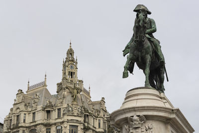 Low angle view of statue of historic building against sky