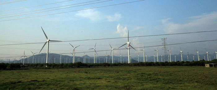 Electricity pylon on field against sky