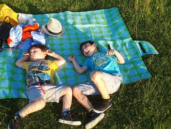 High angle view of friends lying on field