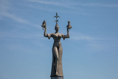 Low angle view of statue against blue sky