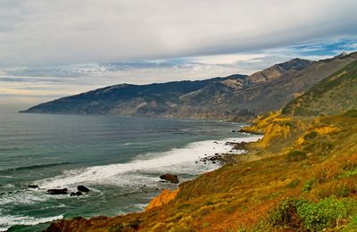 Scenic view of sea and mountains against sky