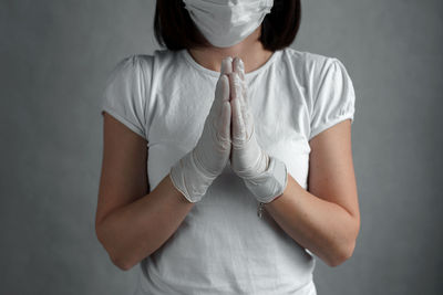 Midsection of woman standing against white background