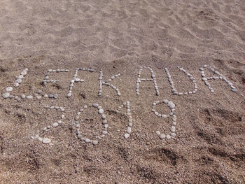 High angle view of text on sand