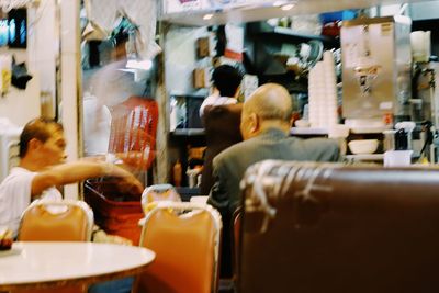 Rear view of woman sitting on shelf