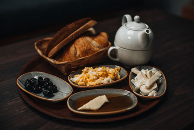 Traditional turkish breakfast with fried egg, olives, croissant, bread, cheese, butter, honey, tea