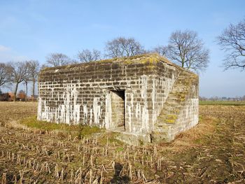 Abandoned built structure on field against sky