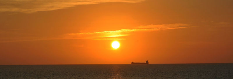 Scenic view of sea against orange sky