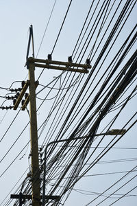 Low angle view of electricity pylon against sky