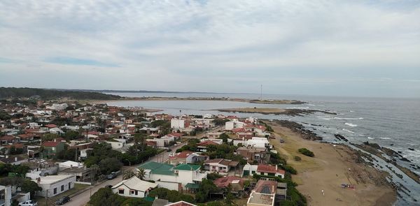 High angle view of townscape by sea against sky