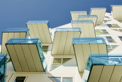 Low angle view of modern buildings against blue sky