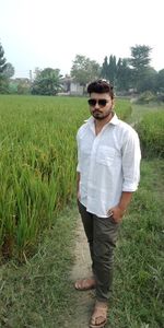 Young man wearing sunglasses standing on field