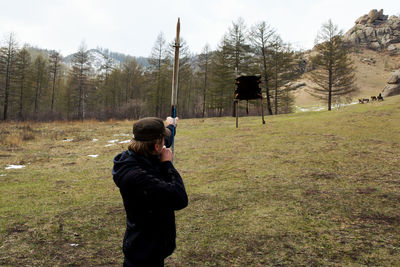 Full length of woman photographing on field