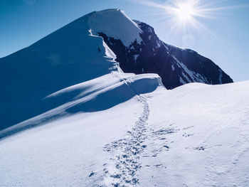 Scenic view of snowcapped mountain against bright sky