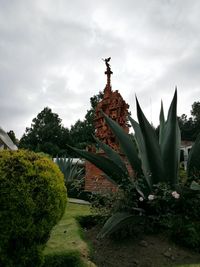 Statue amidst trees against sky