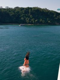 High angle view of woman jumping in sea