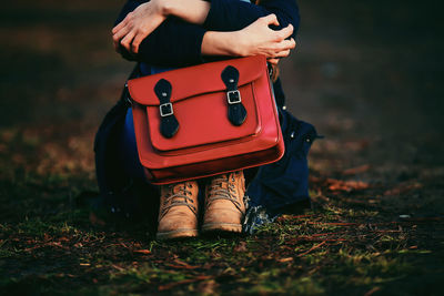 Low section of woman holding suitcase