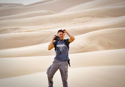 Man photographing from camera at desert