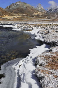 Frozen mountain river and scenic alpine valley surrounded by himalaya mountains, north sikkim, india 