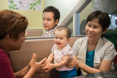 Family playing with cute baby girl at restaurant