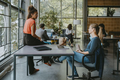 Female and male colleagues discussing while working in new company