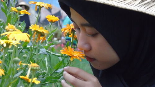 Close-up of woman smelling flowers