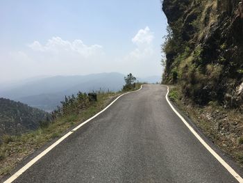 Empty mountain road against sky