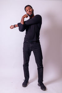 Portrait of young man standing against white background