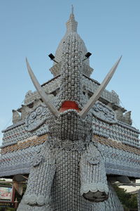 Low angle view of statues on building against sky