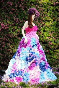 Portrait of woman standing against multi colored plants