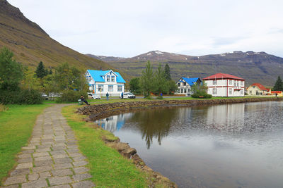 Reflection of houses in lake against mountains