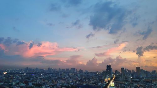 Aerial view of buildings in city against sky during sunset