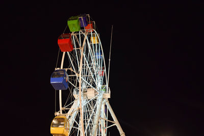 Low angle view of illuminated ferris wheel against sky at night