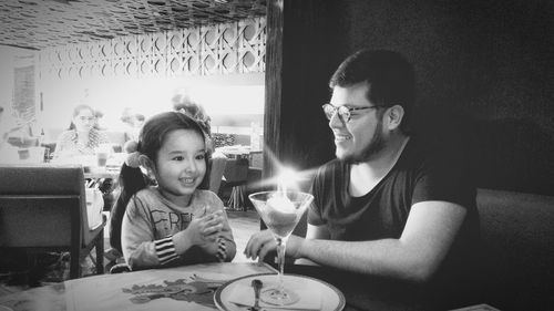 Father and daughter celebrating birthday while sitting at restaurant