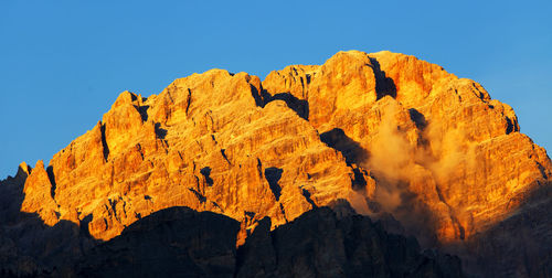 Low angle view of mountain against clear blue sky