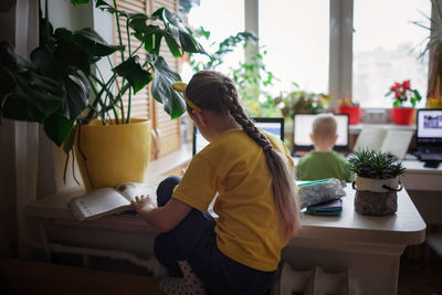 Distant education at home, two siblings doing homework together in one room. elementary school kids